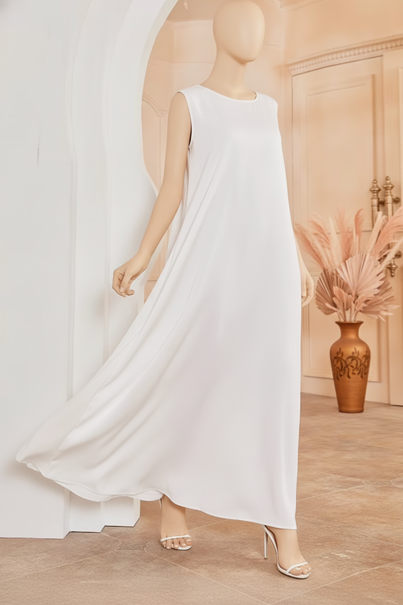 A two-piece AMIRA abaya set on a mannequin in a luxurious Middle Eastern boutique with warm cream walls and ochre accents.